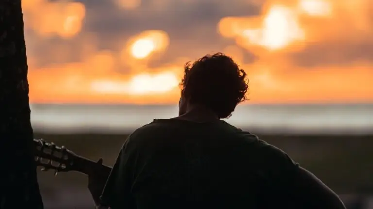 Blog Unah 12 Silhueta de homem tocando violão diante do pôr do sol