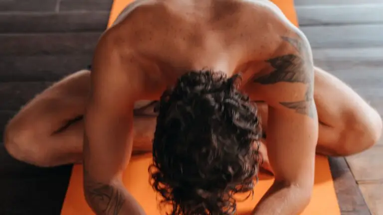 Homem em postura de yoga com a testa apoiada no tapete