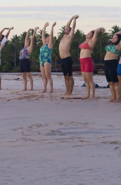 Grupo praticando yoga na praia, na Imersão Unah