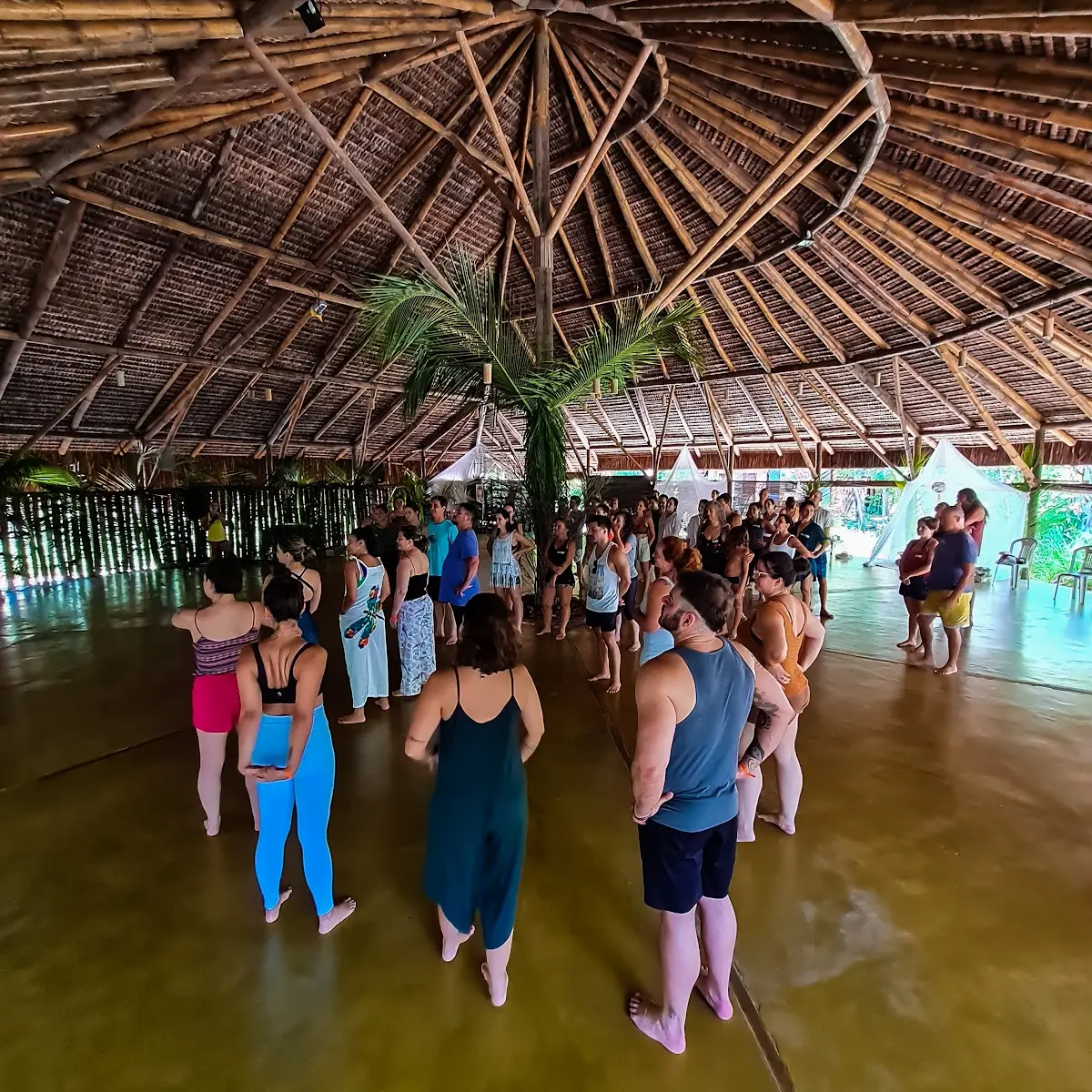 Retreat group moving together inside a shala at Unah, Bahia