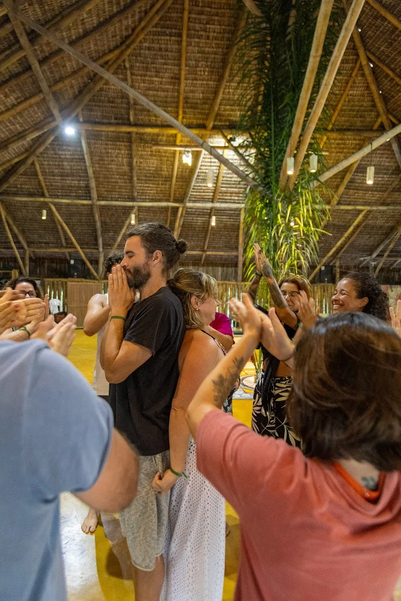 Retreat participants in a circle with hands at heart in a shala at Unah