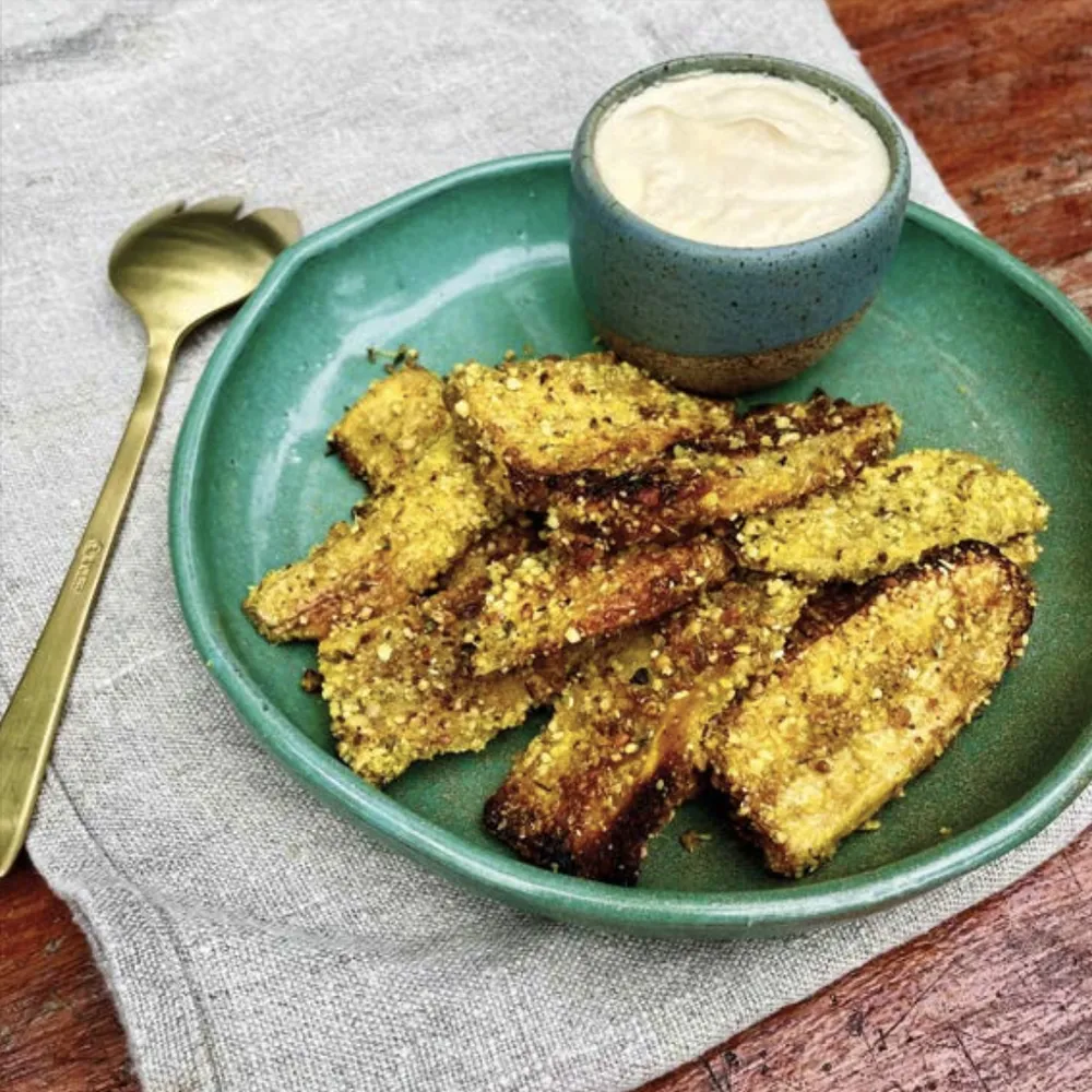 Berinjela empanada vegana com molho cremoso, servida em prato verde no Karuh