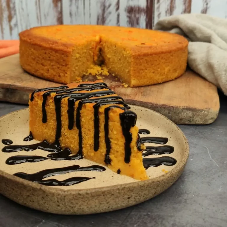Fatia de bolo de cenoura vegano com calda de chocolate servida no Karuh