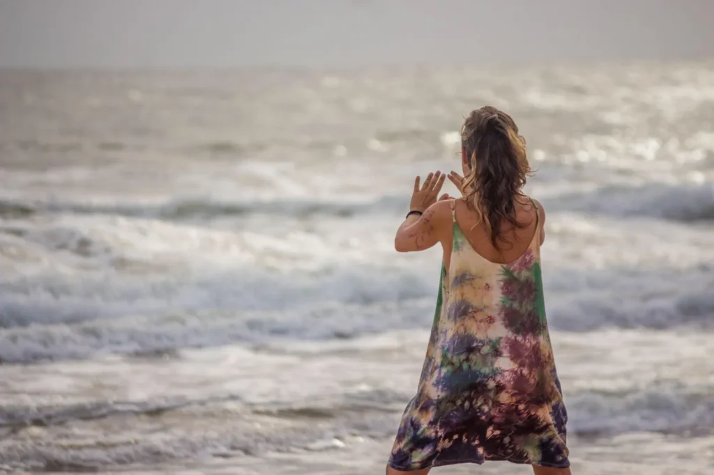 Mulher dançando à beira-mar na praia de Piracanga, Bahia