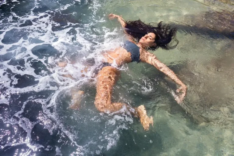 Mulher flutuando nas águas do mar em Piracanga, Bahia