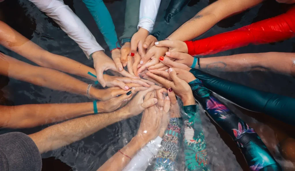Roda de mãos unidas dentro da água no retiro Dança das Águas em Piracanga