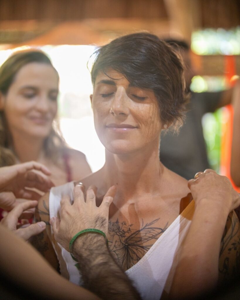 Participante de olhos fechados recebe acolhimento do grupo durante prática em Unah
