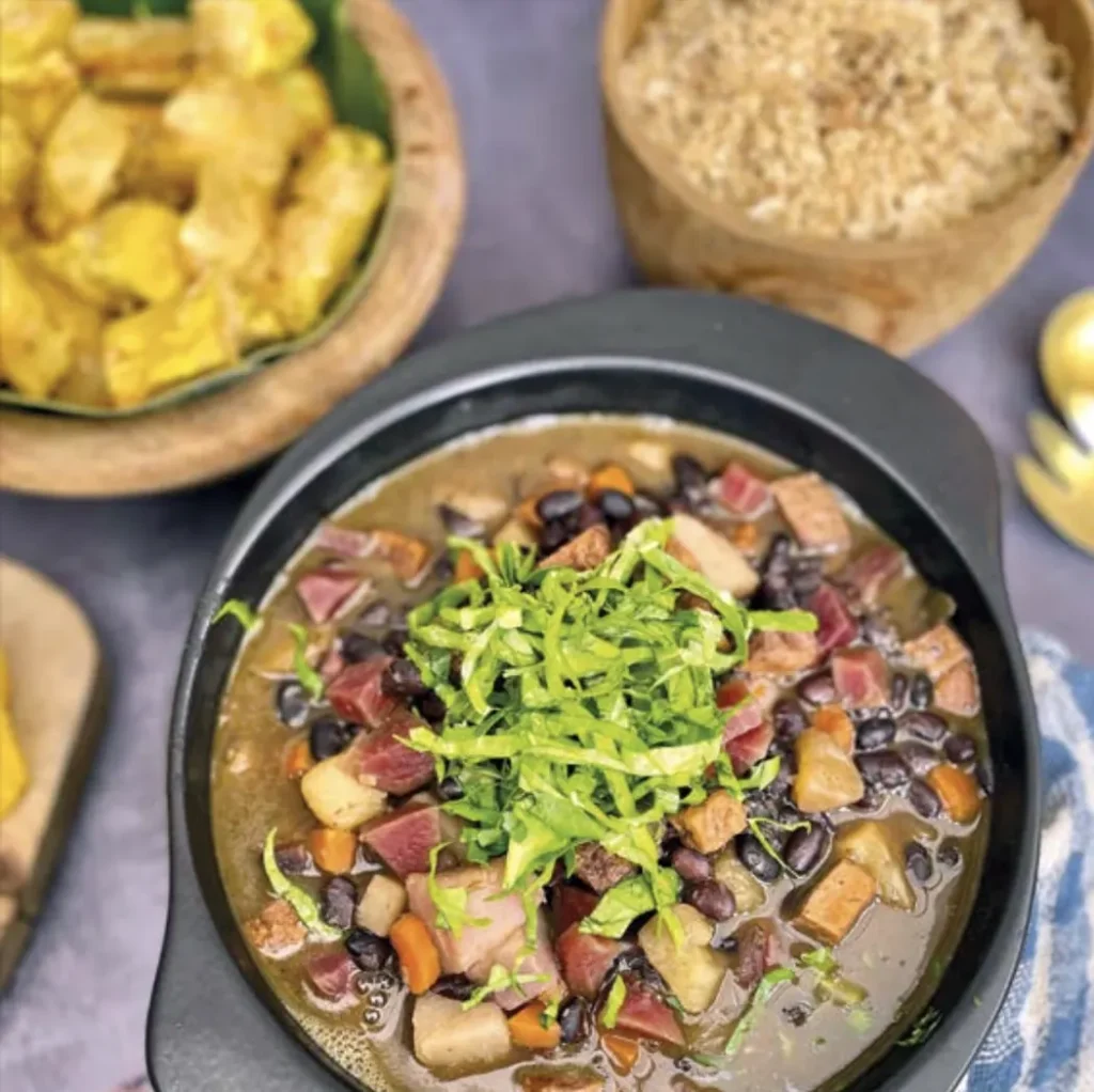Prato vegano com feijão, legumes e couve servido no restaurante de Unah