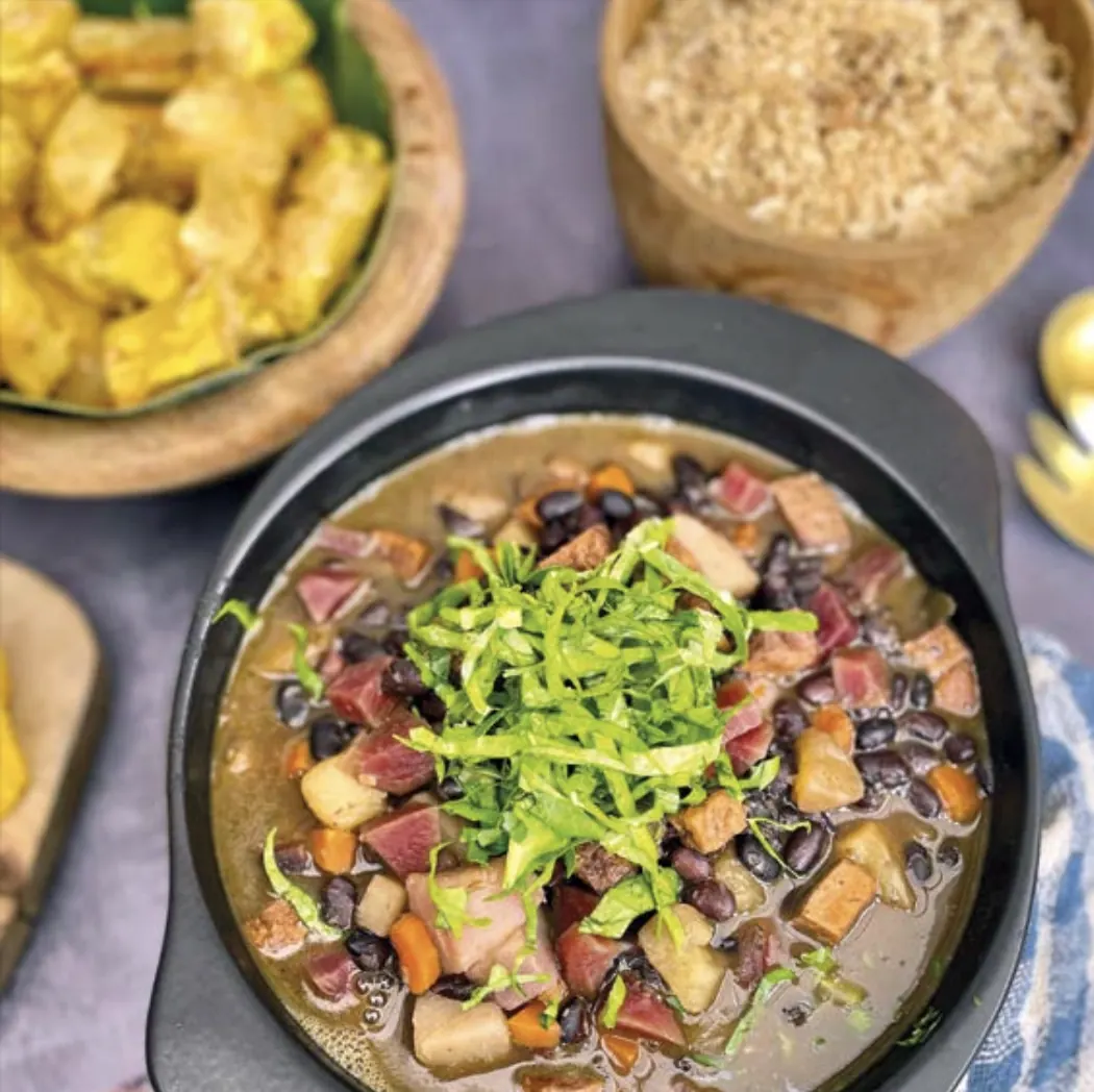 Prato vegano com feijão, legumes e couve servido no restaurante de Unah