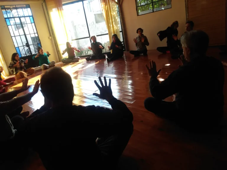 Prática de voz e corpo em roda numa sala iluminada