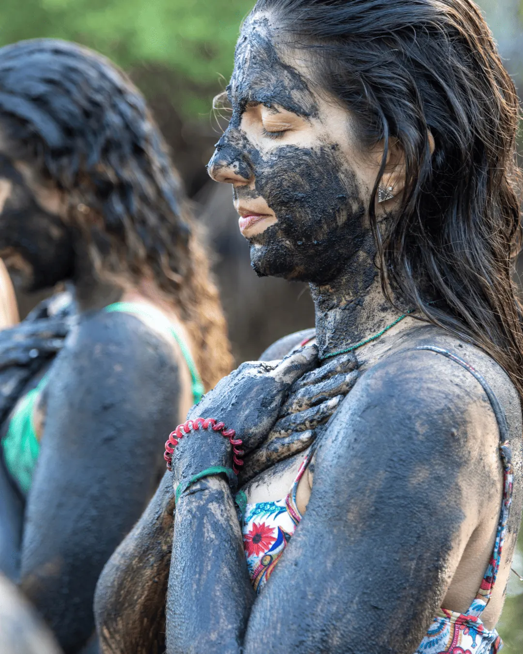 Participante com argila no rosto em vivência de conexão com a Natureza